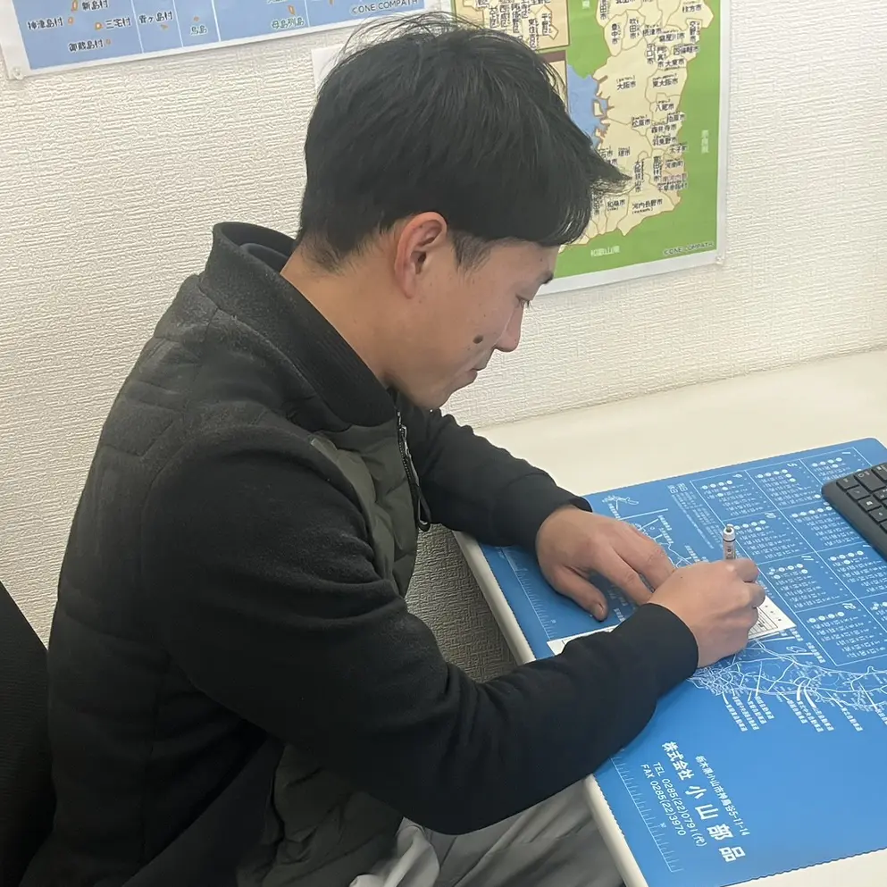 帰社して報告書を書く様子